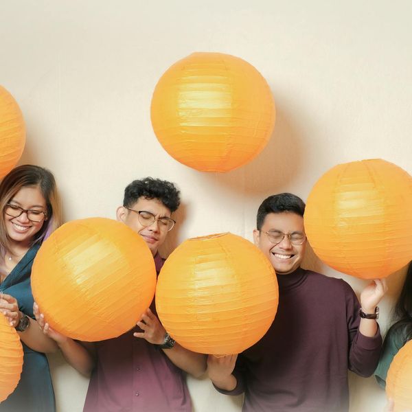 Diverse group of people smiling during a light yoga session in a bright studio.
