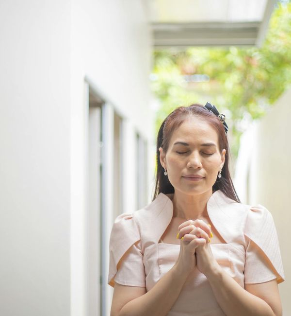 Person meditating peacefully outdoors with a soft, natural background.